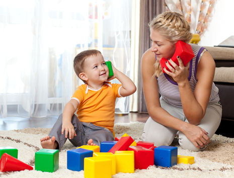 autistic child and therapist playing with colorful blocks on carpet