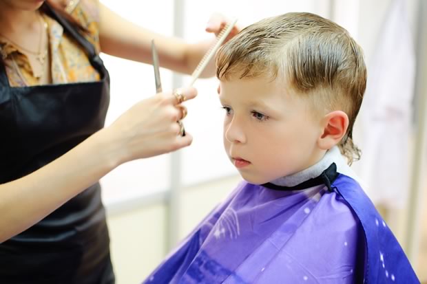 young child with autism getting a haircut