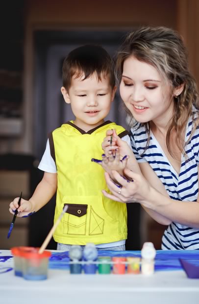 therapist and child with autism painting